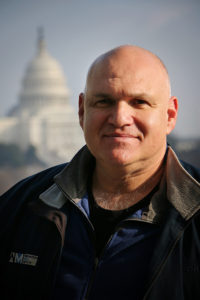 a professional headshot of Amos Gelb
